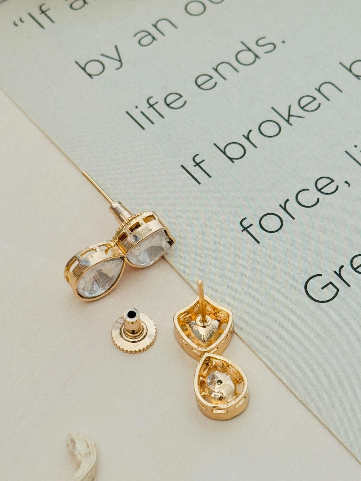 Close-up of Gold Plated Uncut Polki Pendant Chain earrings by Abdesignsjewellery on printed paper background