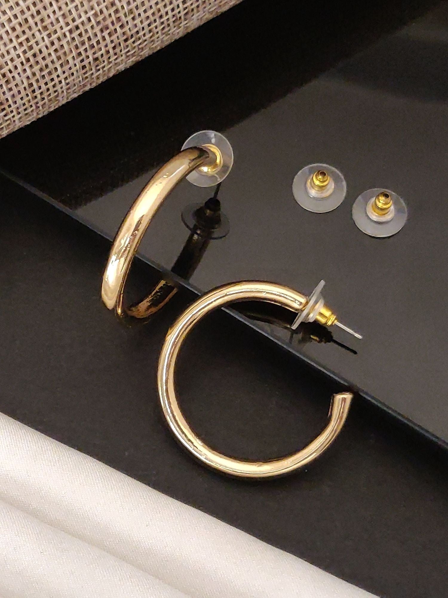 Gold Plated Western Hoop Earring displayed with clear backing and stylish fabric background