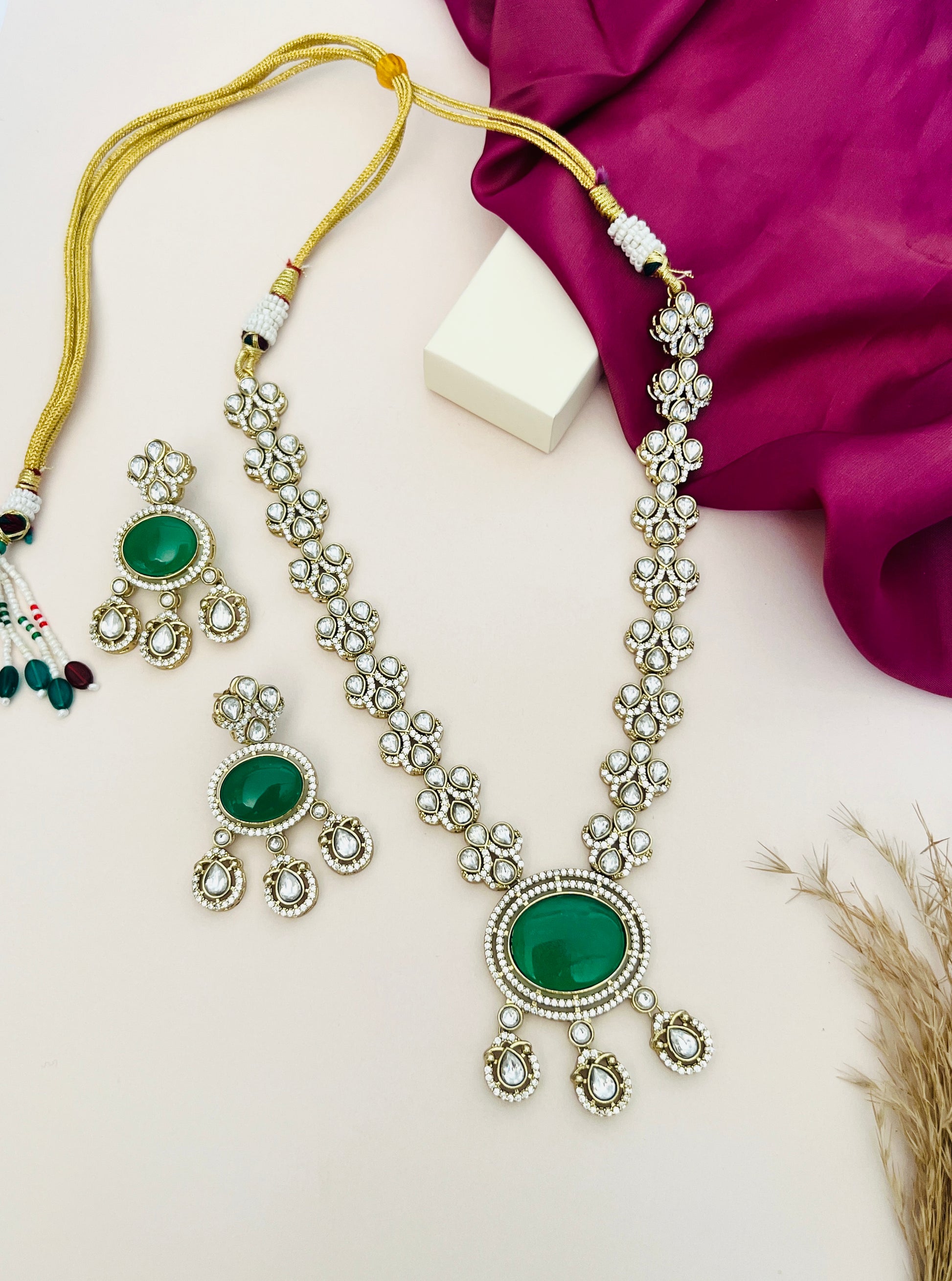 Abdesignsjewellery Green Emerald Polki Gold Plated Necklace Set with matching earrings on a beige background