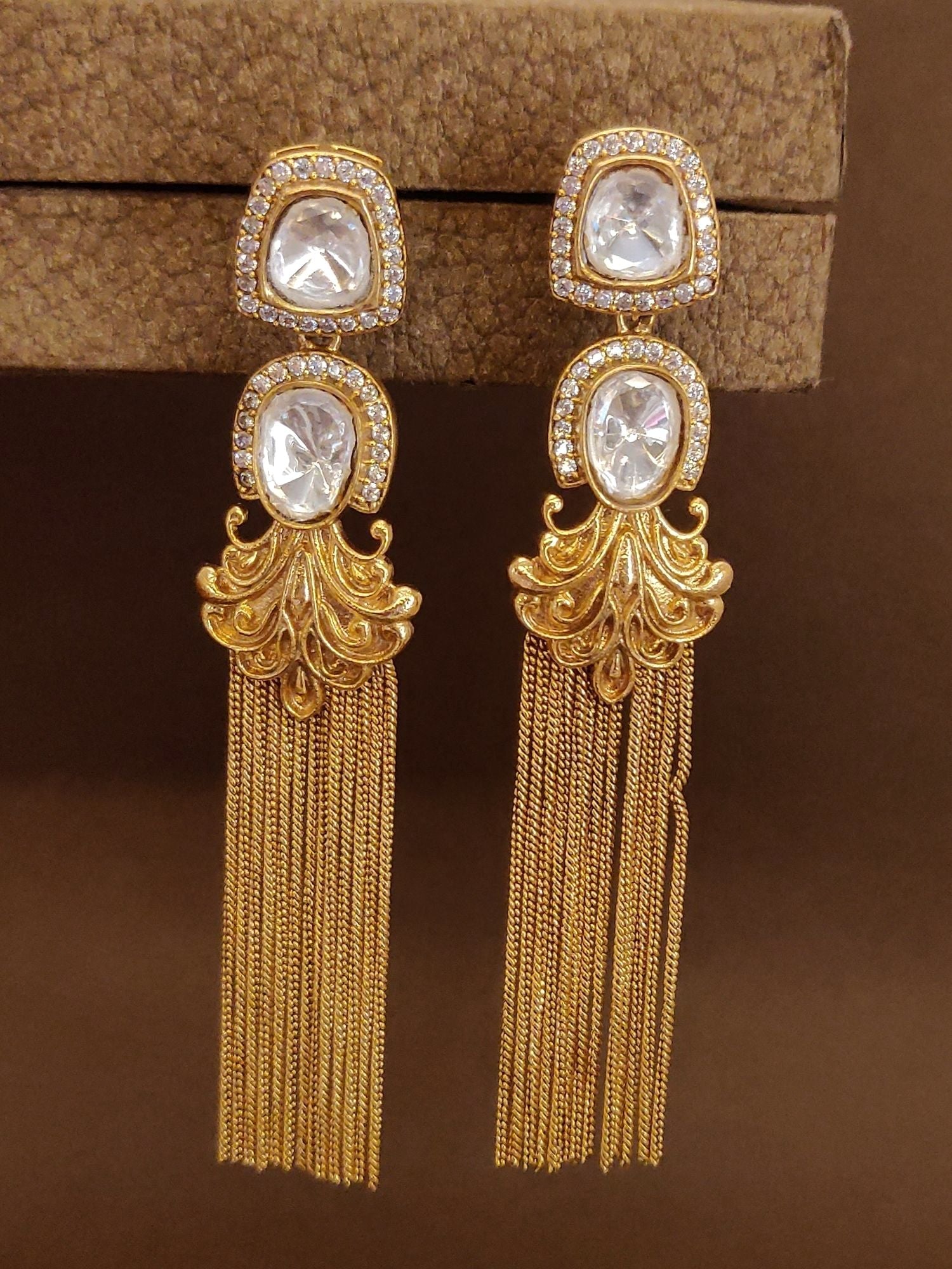 Long gold plated polki earrings with intricate design and cascading tassels for elegant style