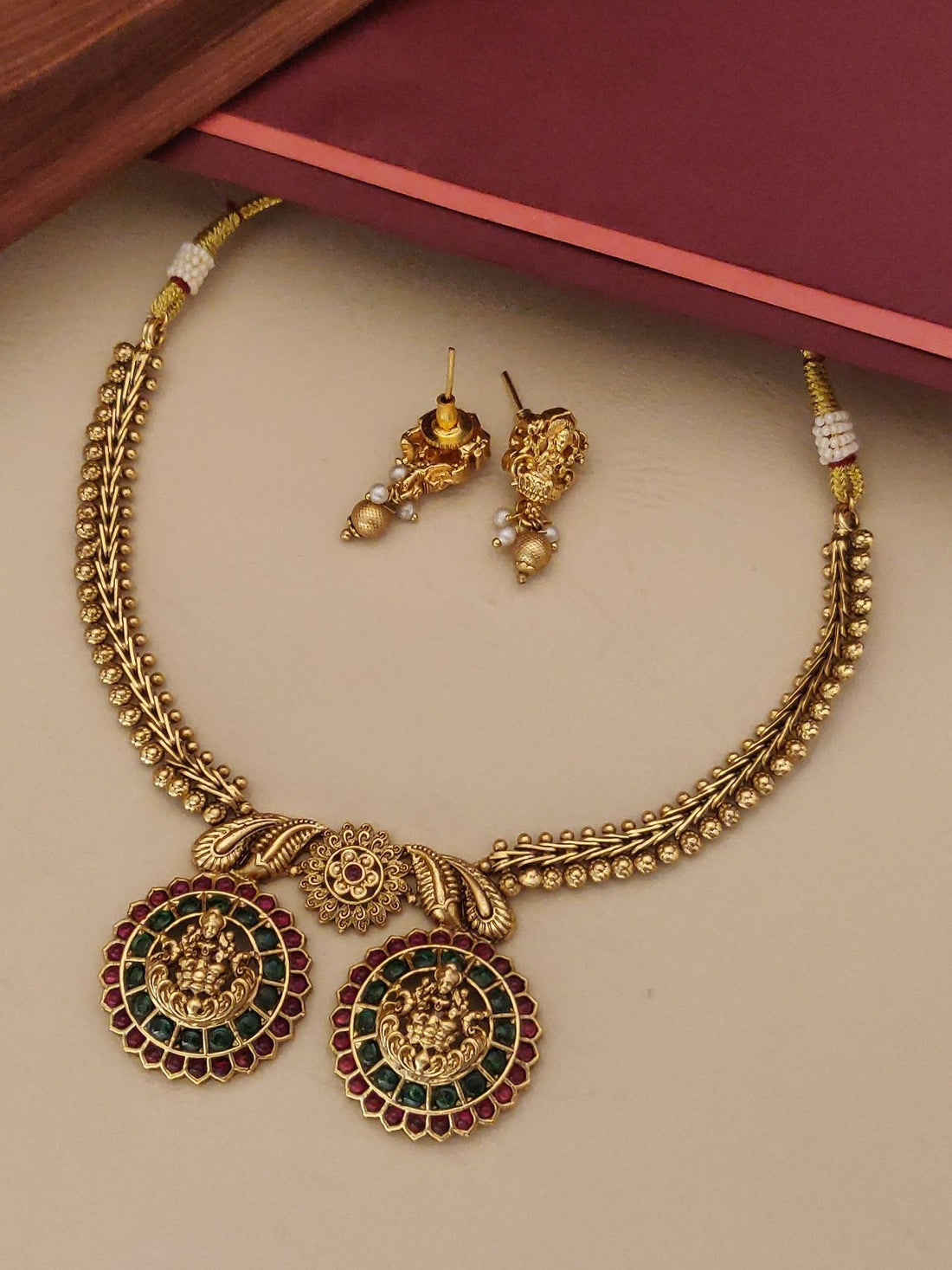 Elegant matt gold necklace for women featuring intricate designs and colorful gemstone accents