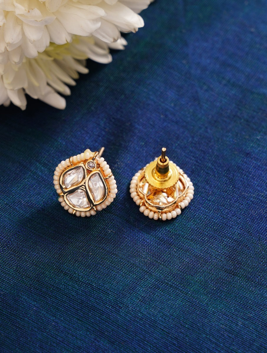 Party Wear Polki Pearls Necklace Set gold and pearl stud earrings by Abdesignsjewellery on blue fabric