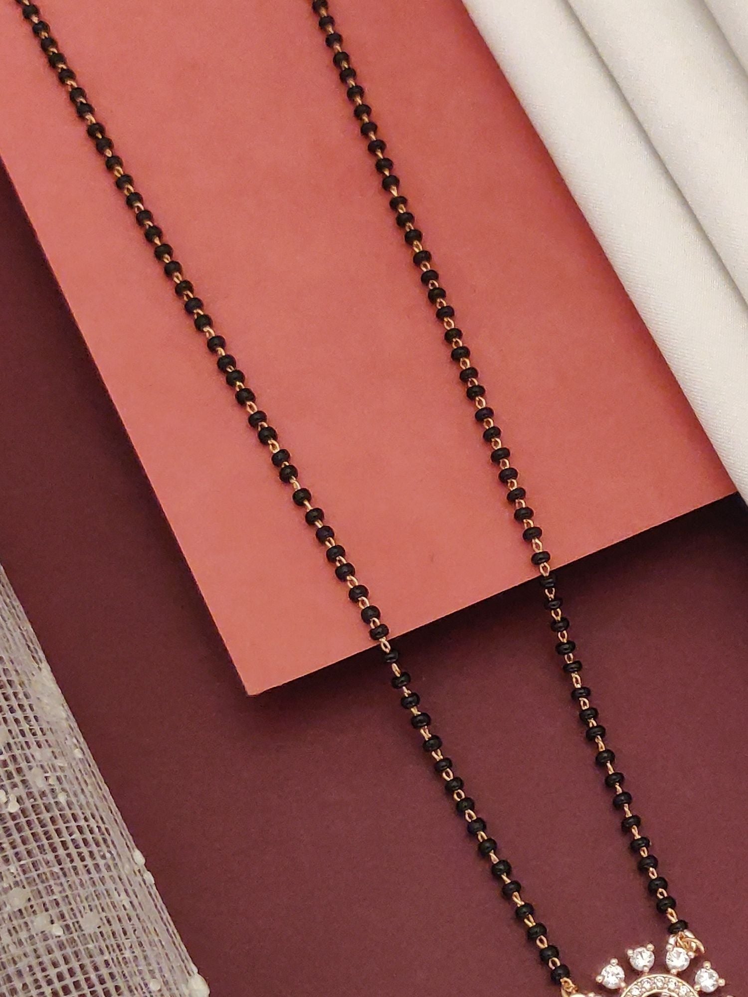 Abdesignsjewellery rose gold plated diamond mangalsutra with black beads and pendant showing diamond accents