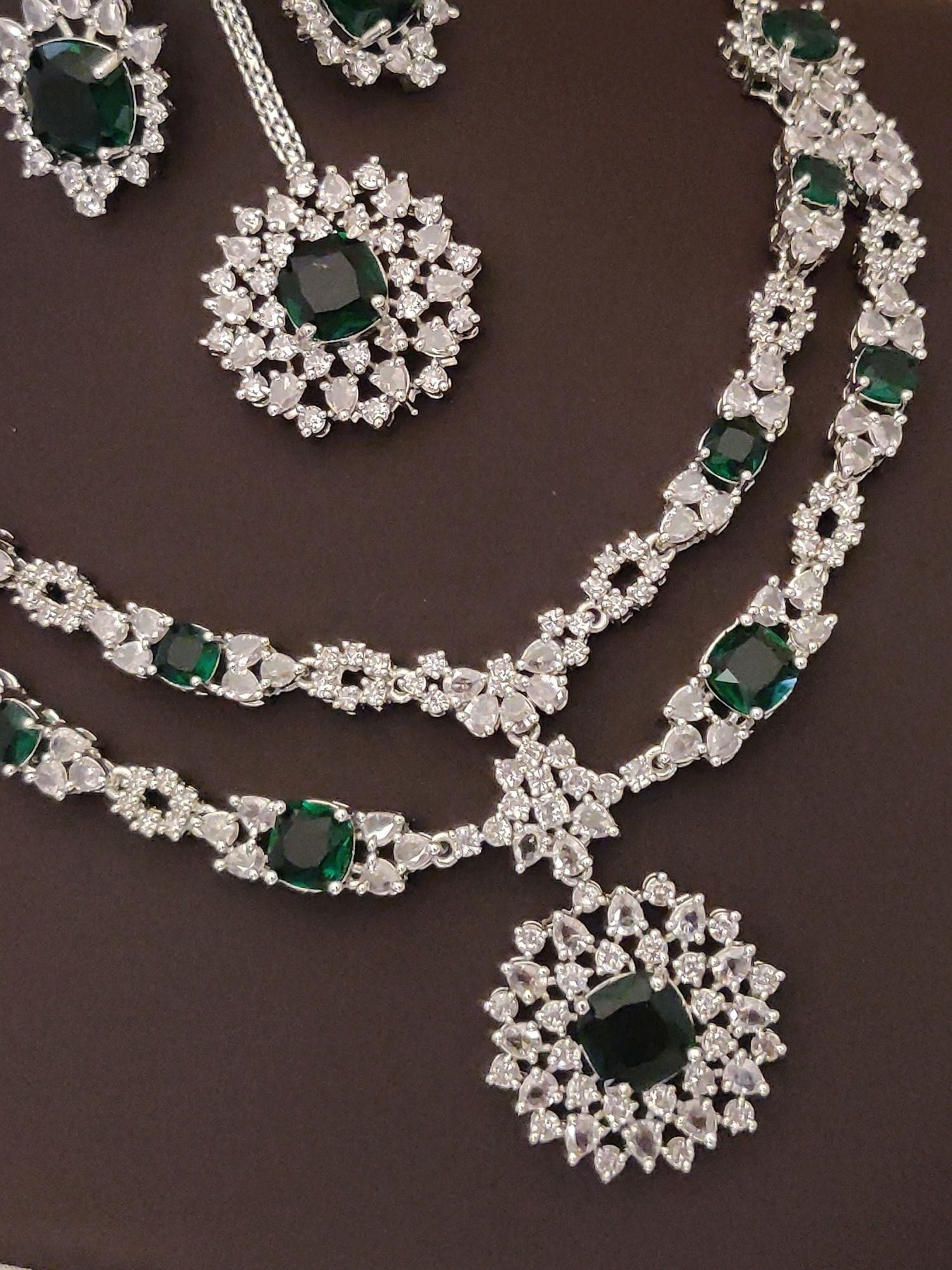 Elegant silver plated American diamond necklace set featuring intricate designs and emerald accents