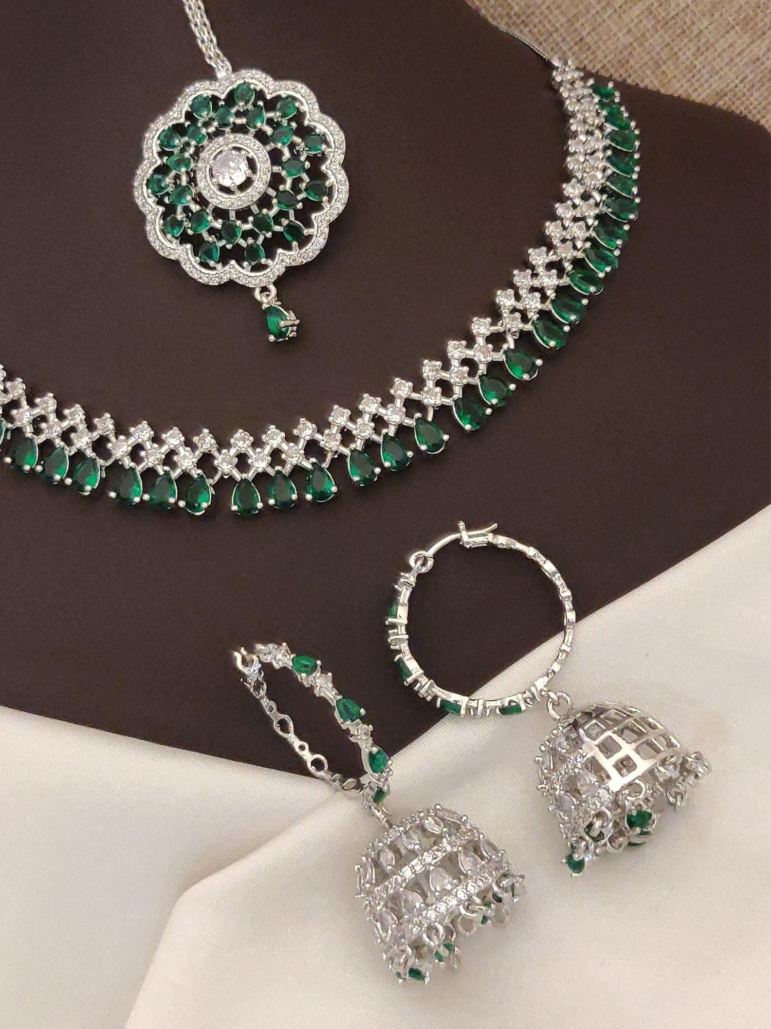 Elegant silver plated American diamond necklace set with intricate green stones and matching earrings