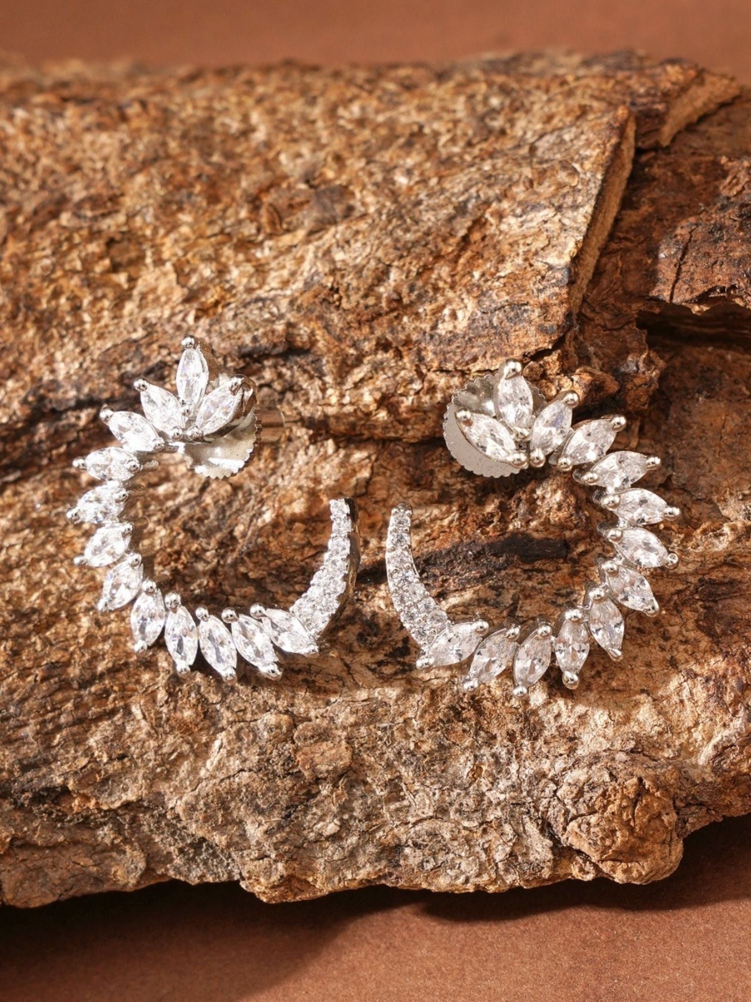 Sparkling Silver Plated American Diamond Stud Earring with intricate leaf design on rustic background