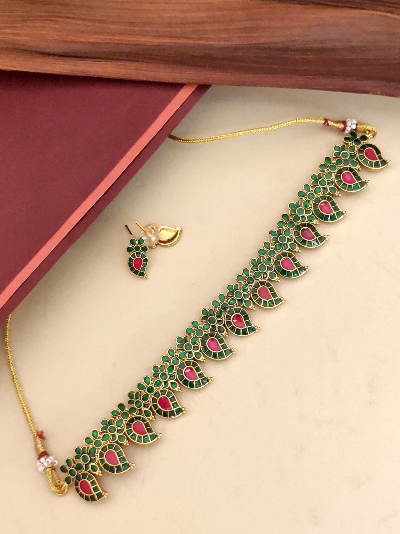 Traditional Kemp stone jewelry necklace featuring intricate green and red designs on a golden chain