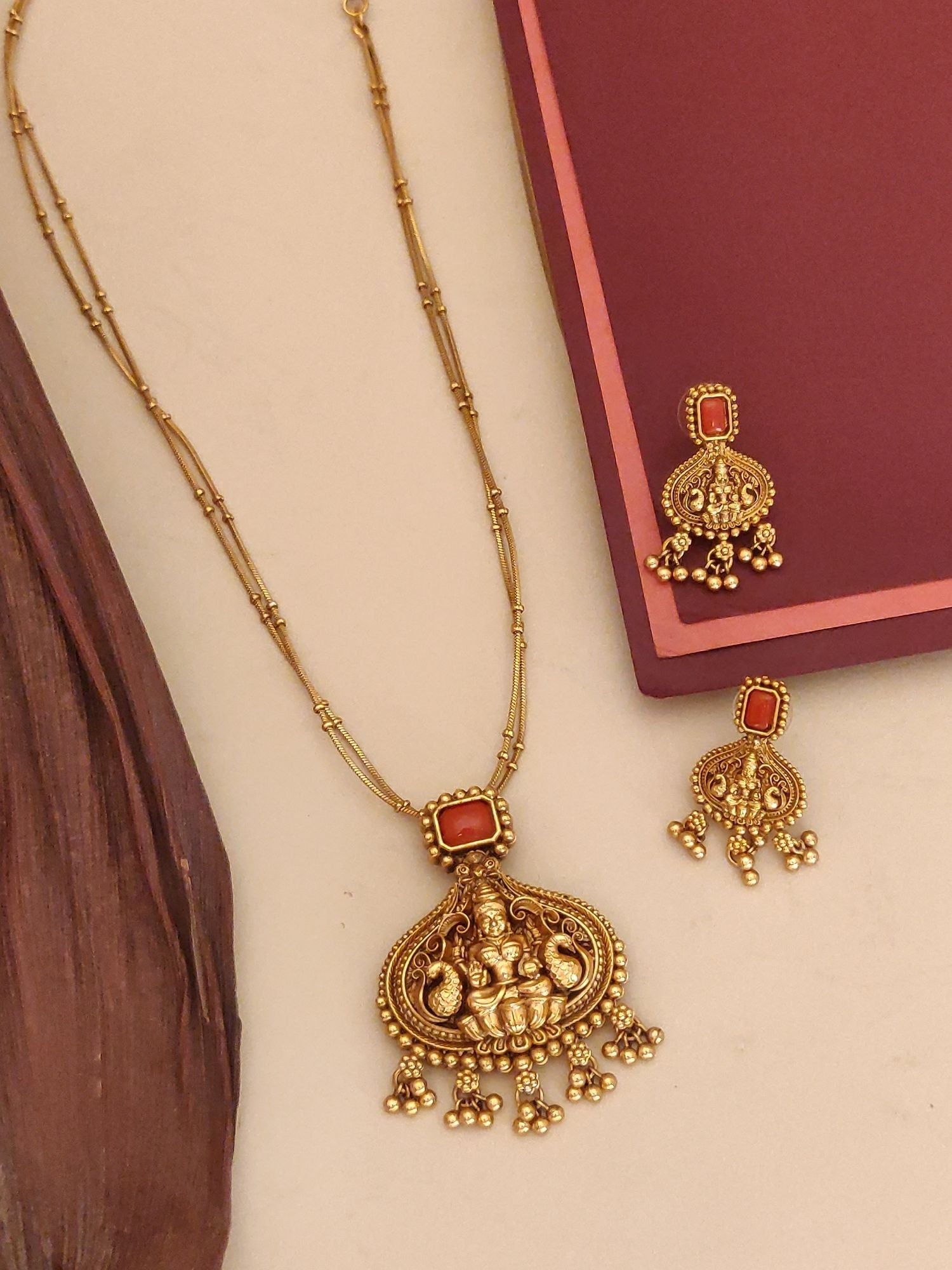 Antique gold traditional pendant chain necklace with ornate temple style pendant red stone accents and matching earrings
