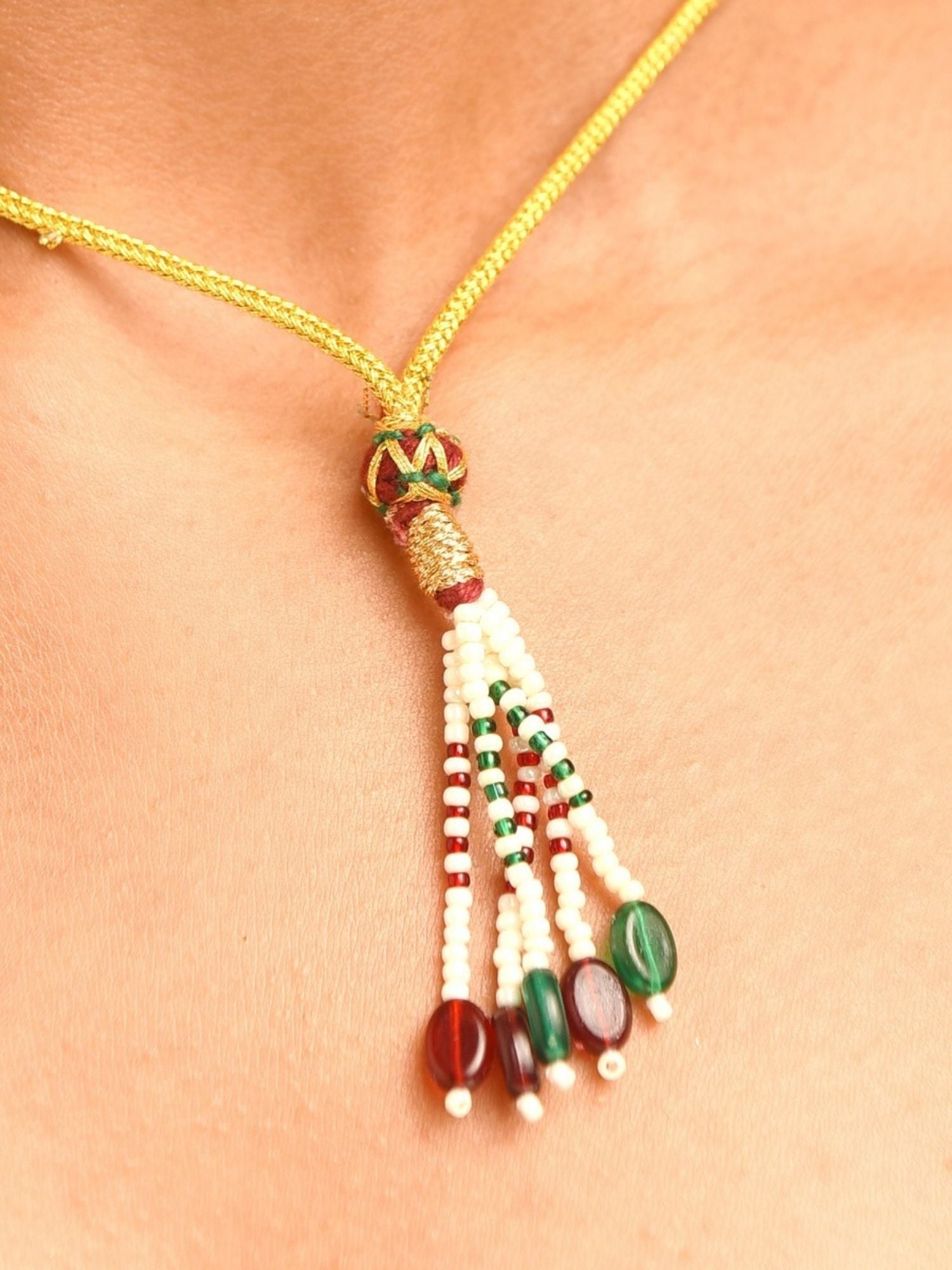 Abdesignsjewellery beaded tassel necklace on model with gold cord and red green beads premium designer choker necklace India