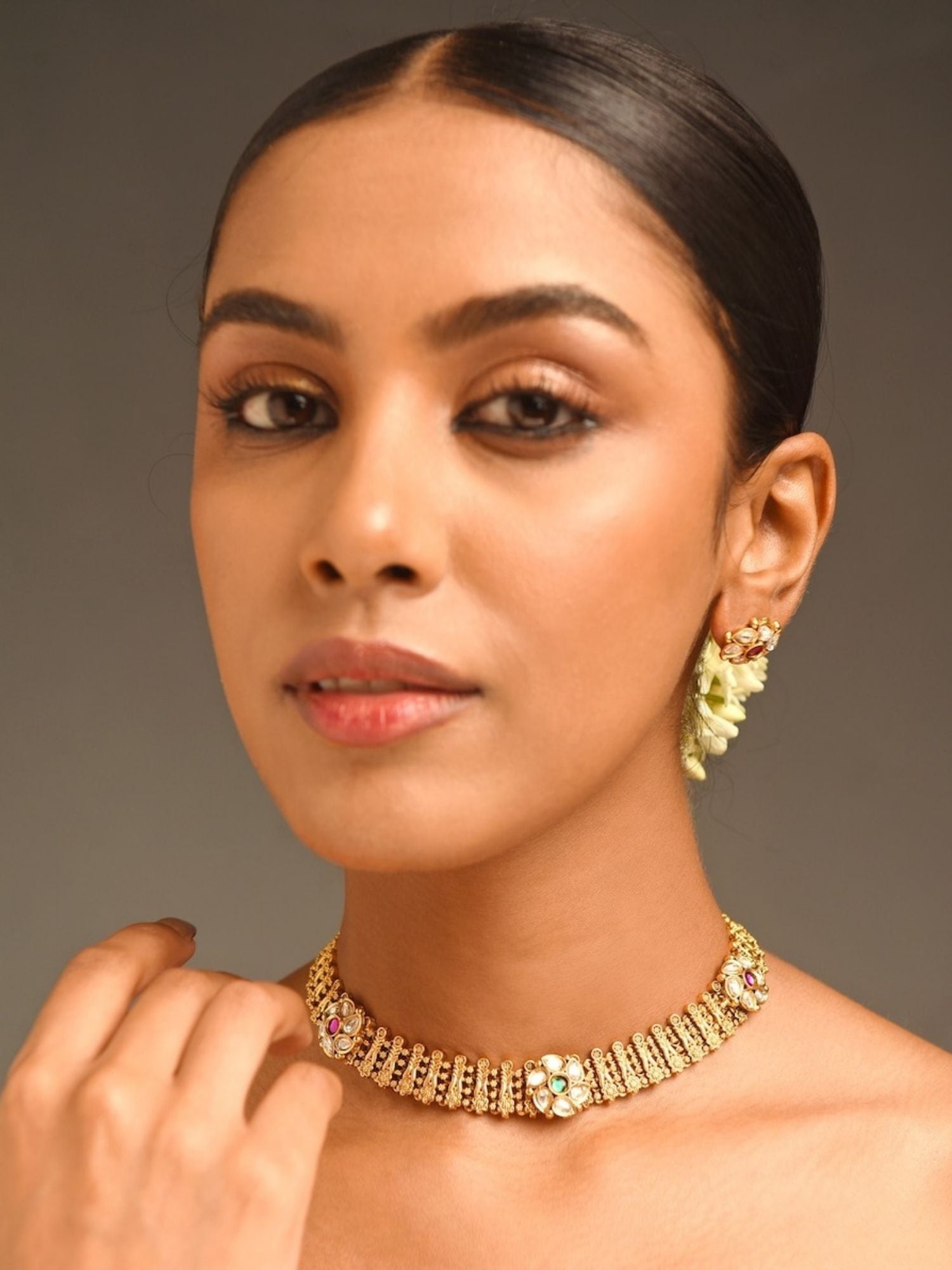Abdesignsjewellery model wearing gold floral premium designer choker necklace India with gemstone accents