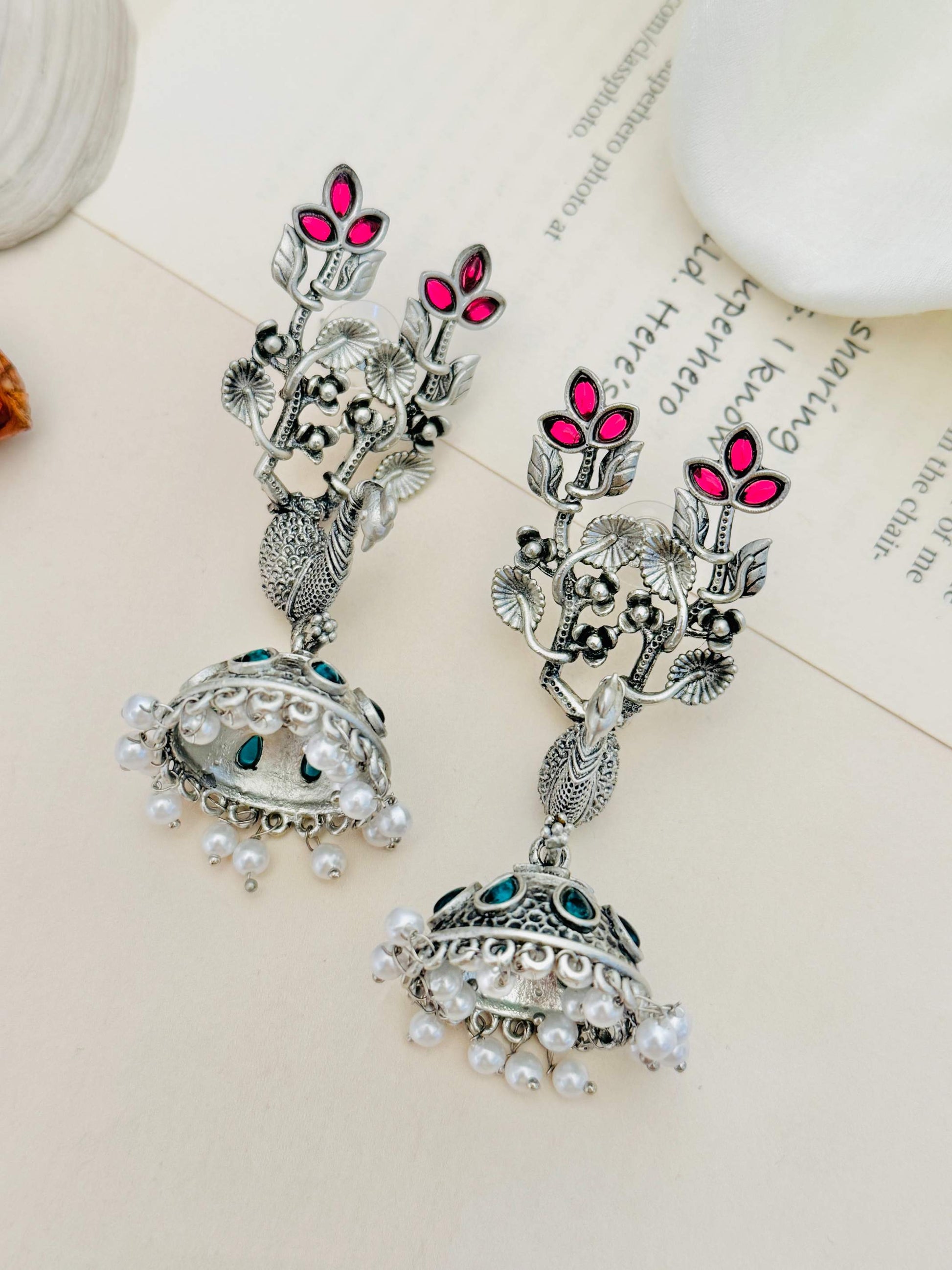 Long Peacock German Silver Plated Earrings with intricate floral design and pearl details by Abdesignsjewellery