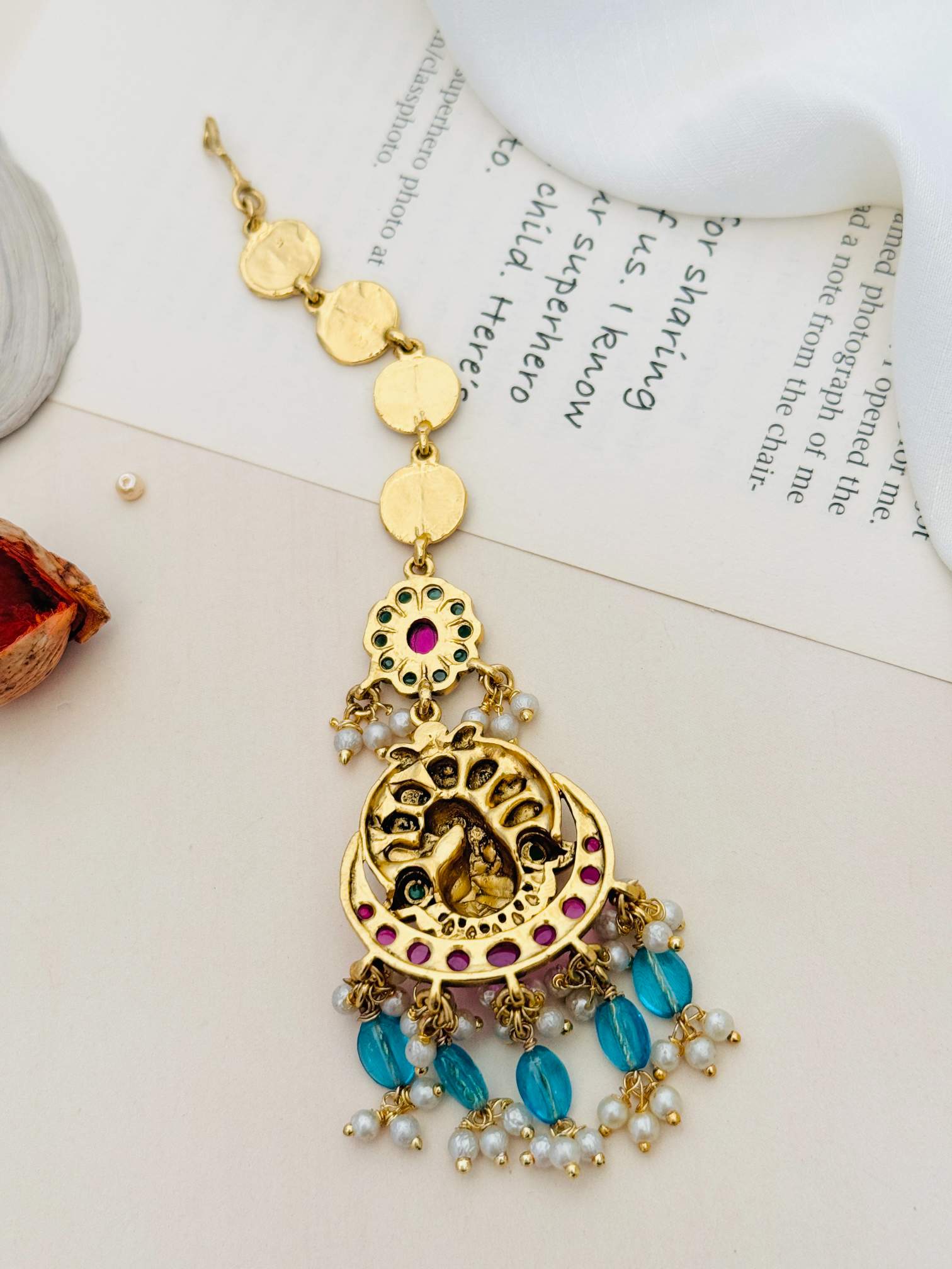 Multistone Sky Blue Matt Gold Plated Peacock Style Maangtikka with blue beads and pearl accents