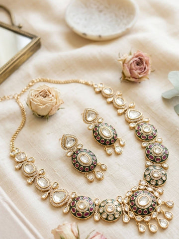 Elegant name gold plated necklace with colorful stones and matching earrings on a soft background