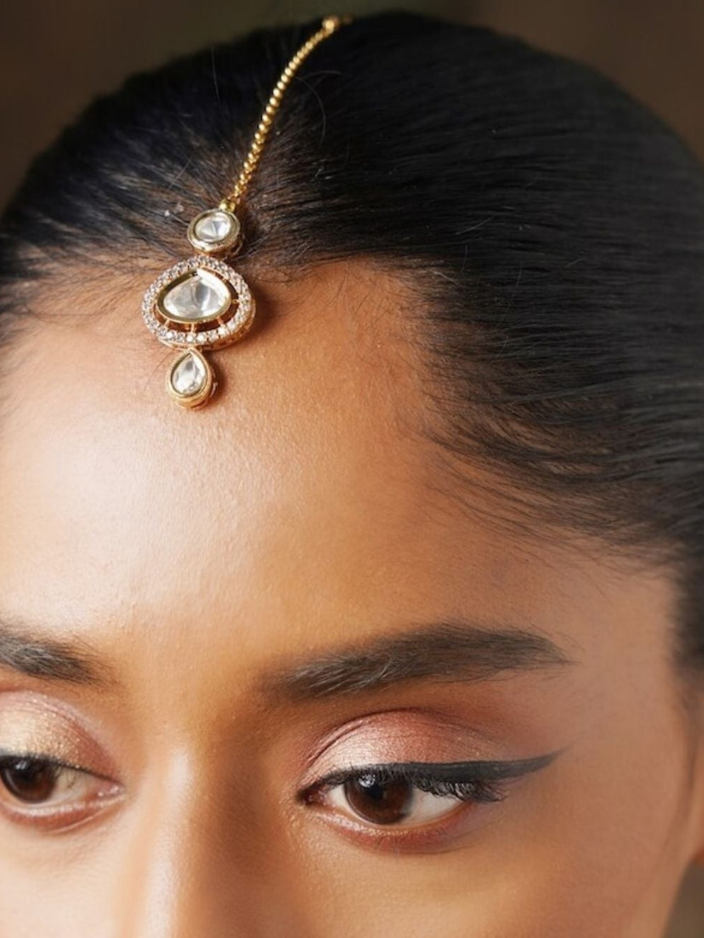 Polki Kundan Drop Maangtikka worn on forehead showcasing traditional gold and stone design