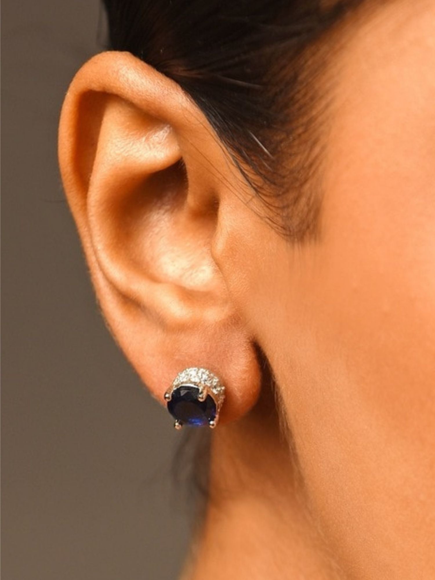 Precious Silver Plated American Diamond Stud Earring with dark blue stone worn on ear by Abdesignsjewellery