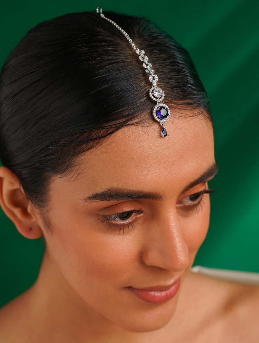 Round Silver Plated American Diamond Maangtikka worn by woman with sleek hair against green background