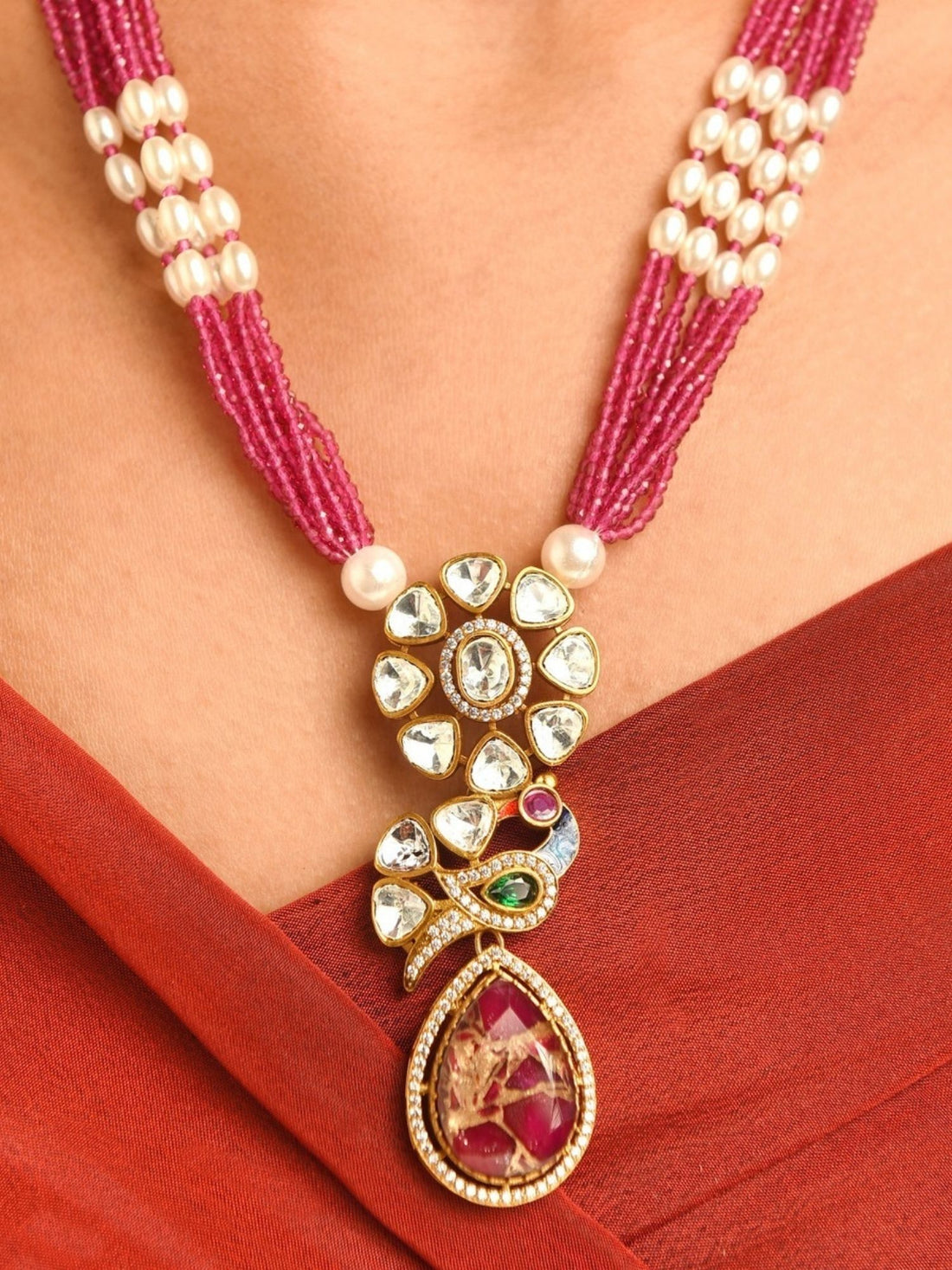 Royal Gold Plated Long Pearl Polki Peacock Necklace Set worn by woman with red dress and matching earrings