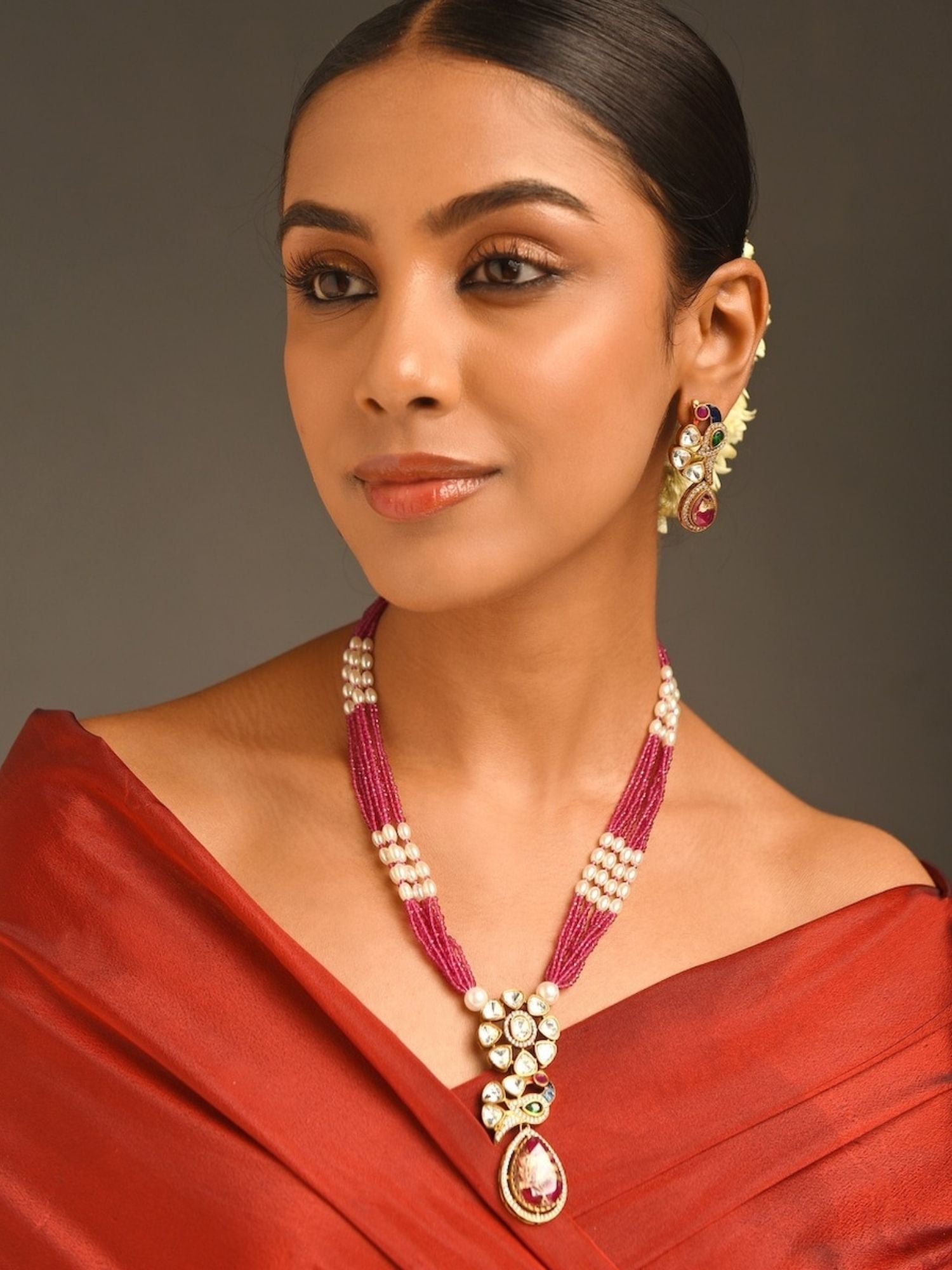 Royal Gold Plated Long Pearl Polki Peacock Necklace Set worn by woman with red dress and matching earrings