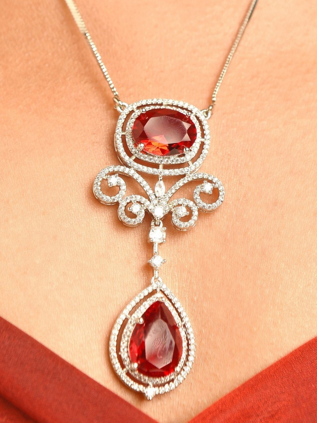 Model wearing Abdesignsjewellery silver plated ruby pendant set with double teardrop ruby drops and matching earrings