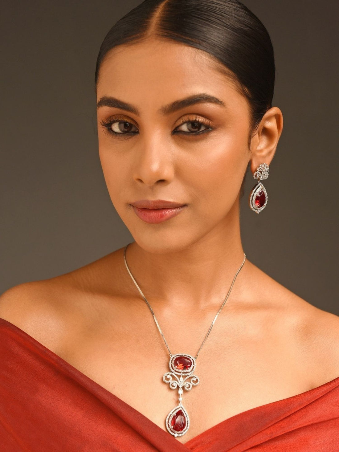 Model wearing Abdesignsjewellery silver plated ruby pendant set with double teardrop ruby drops and matching earrings