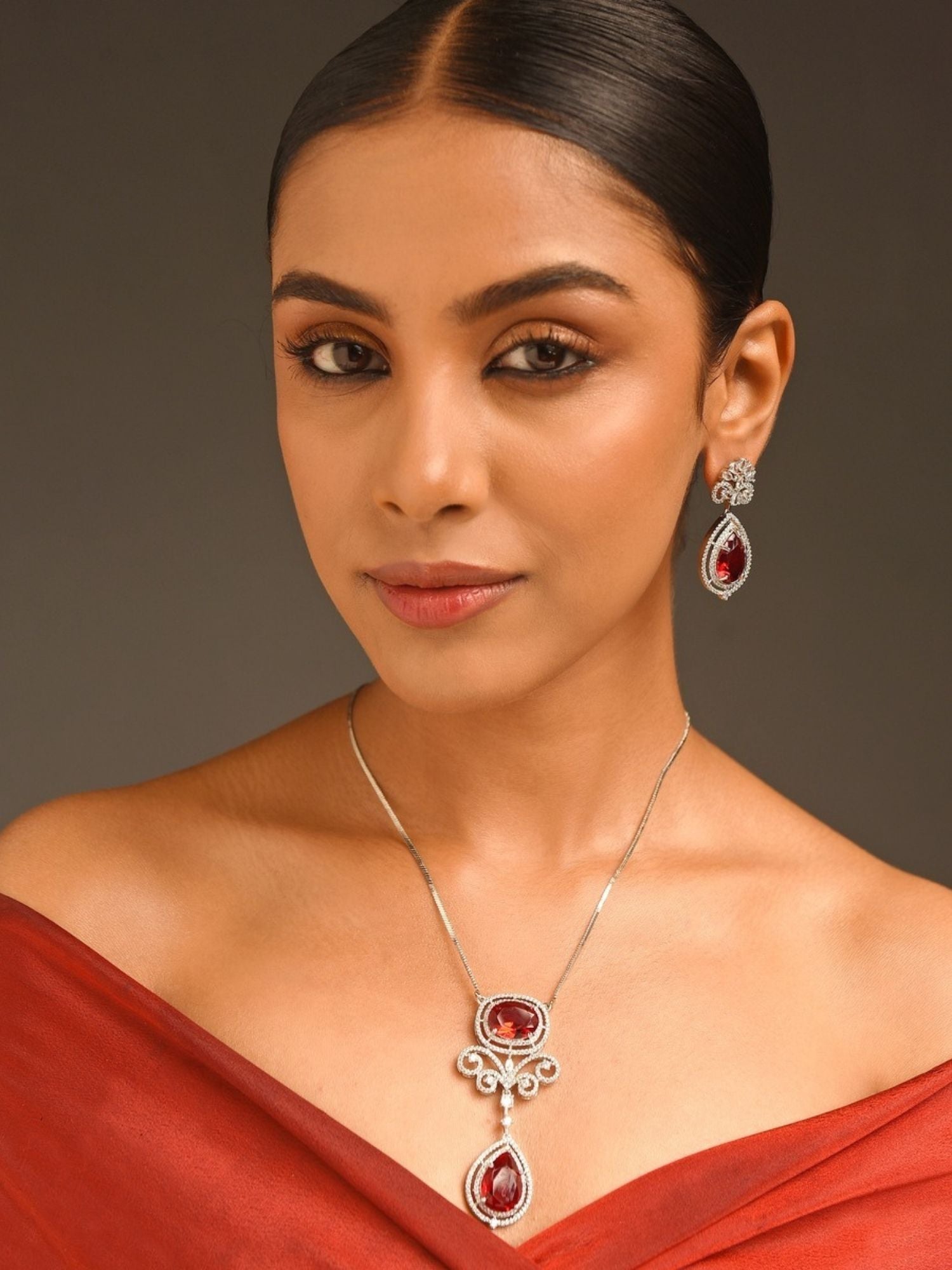 Model wearing Abdesignsjewellery silver plated ruby pendant set with double teardrop ruby drops and matching earrings