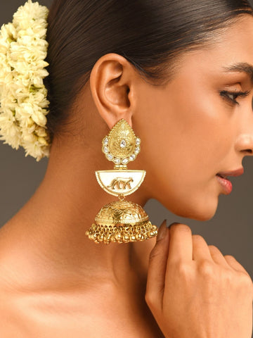 Sabyasachi Style Gold Plated Jhumka Earrings with intricate design worn by model with floral hair accessory