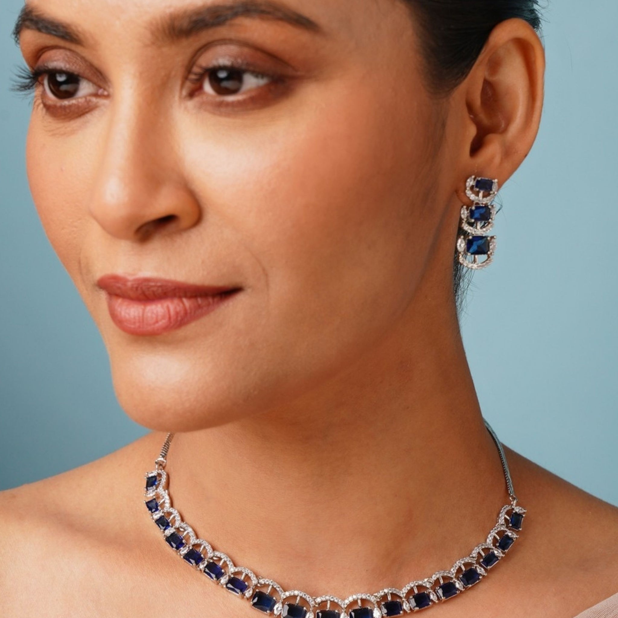 Silver American Diamond Necklace Set with blue stones worn by woman in elegant style