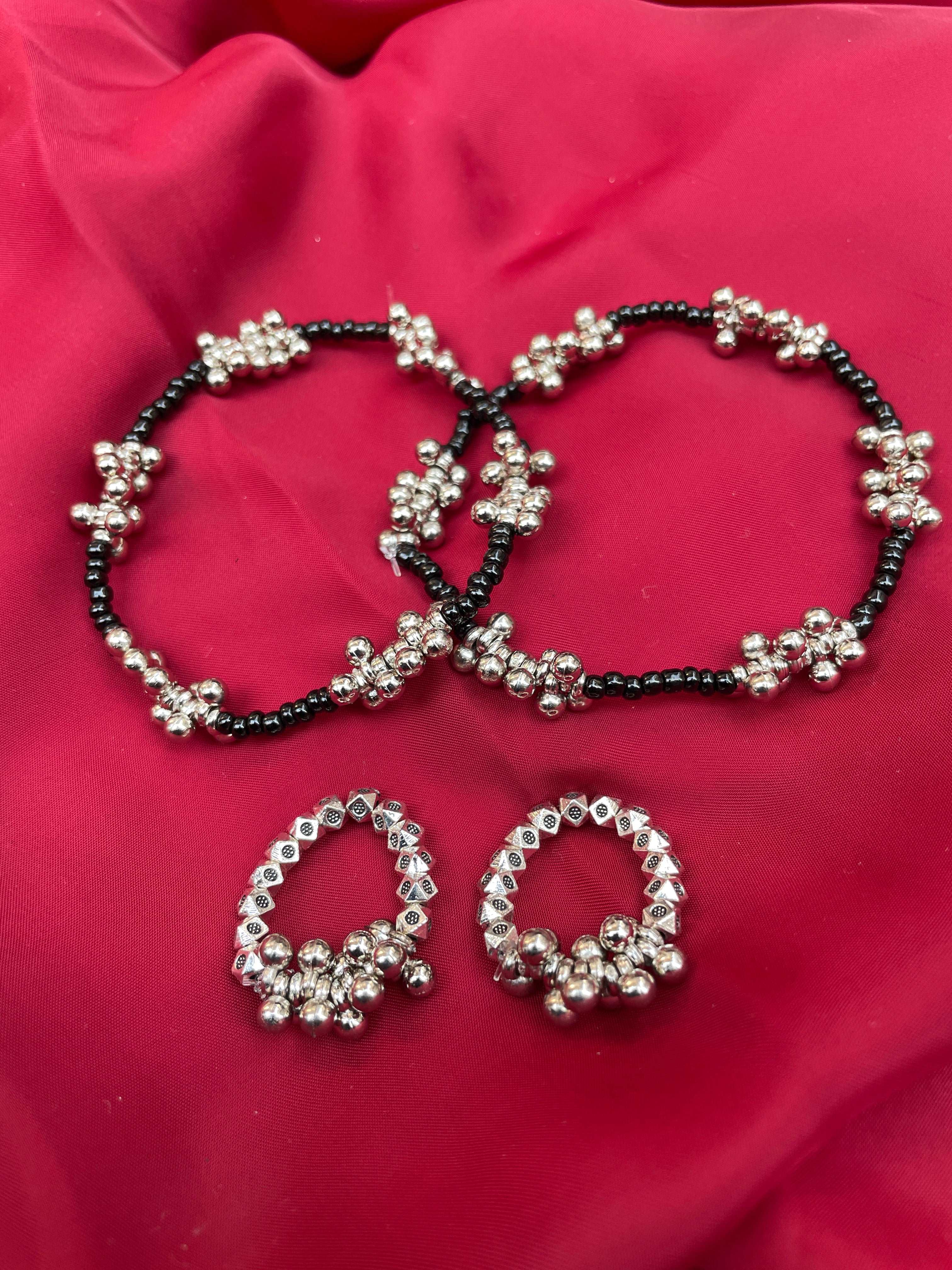 gungru anklet toe ring combo black beaded anklets with silver floral clusters and matching silver toe rings on red fabric