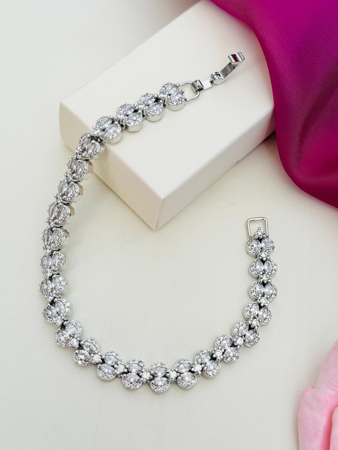 Silver Plated American Diamond Bracelet from Abdesignsjewellery displayed on white surface with pink fabric and flower
