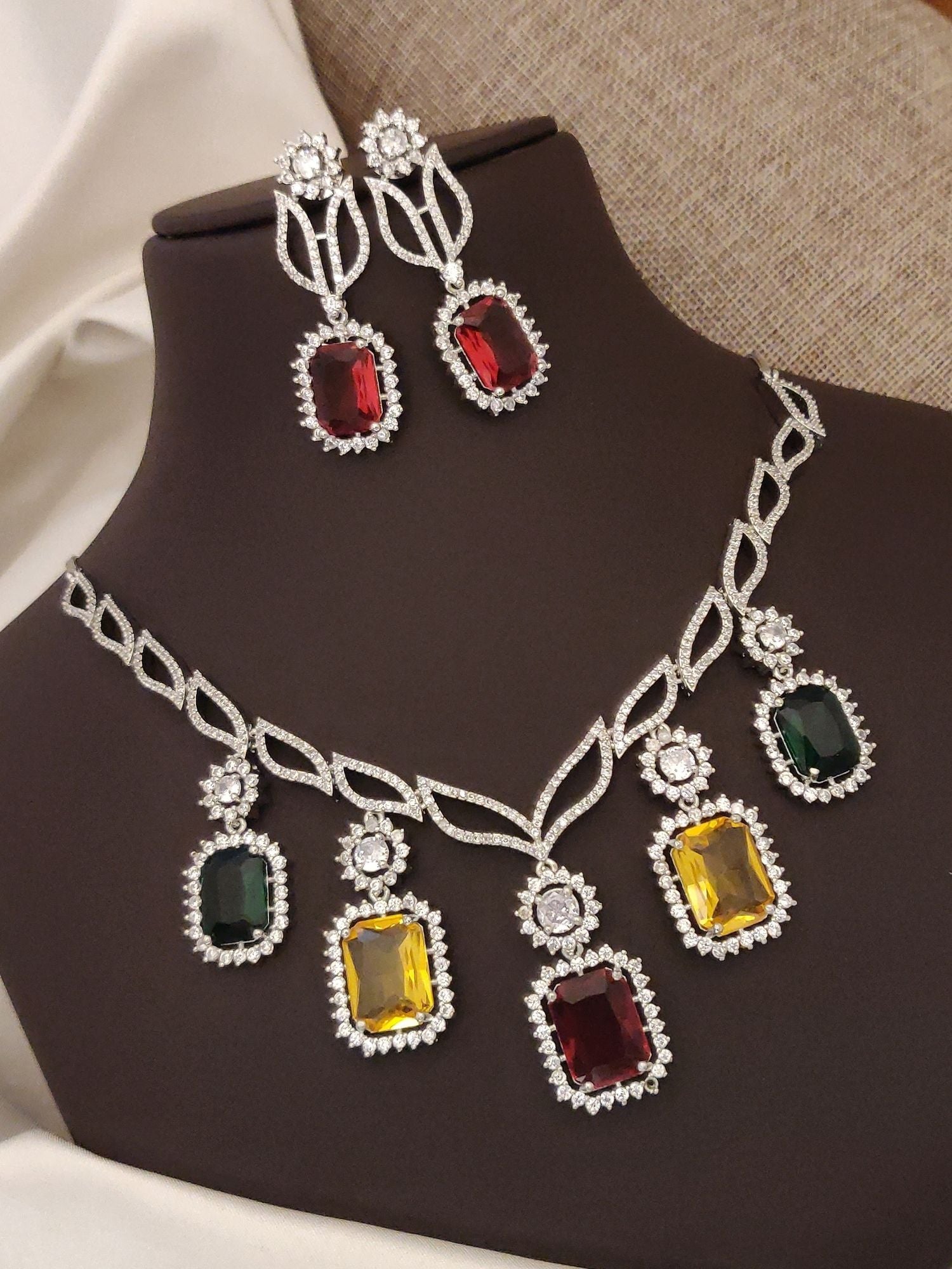 Elegant silver plated American diamond necklace set with colorful gemstone accents and matching earrings