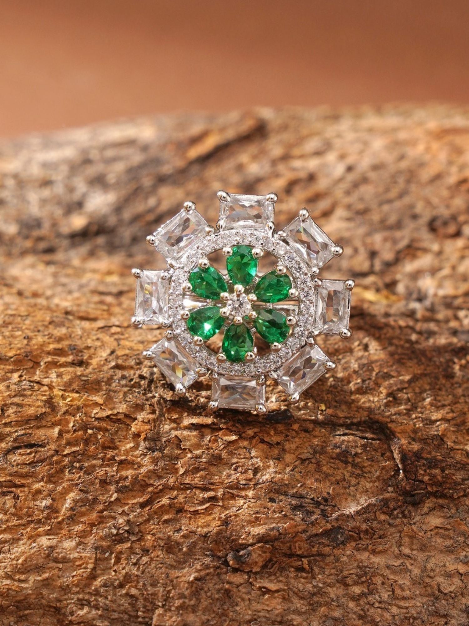 Silver Plated Elegant Design Ring with green and clear gemstones on rustic wood background