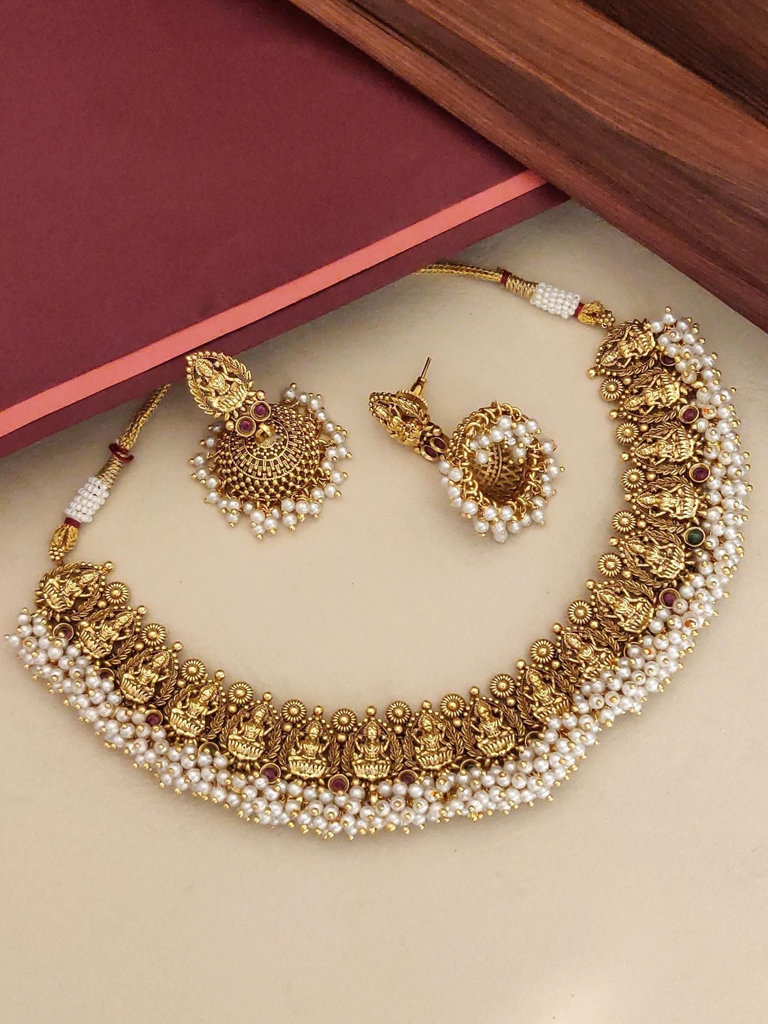 South Indian antique temple necklace with intricate deity designs and pearl embellishments