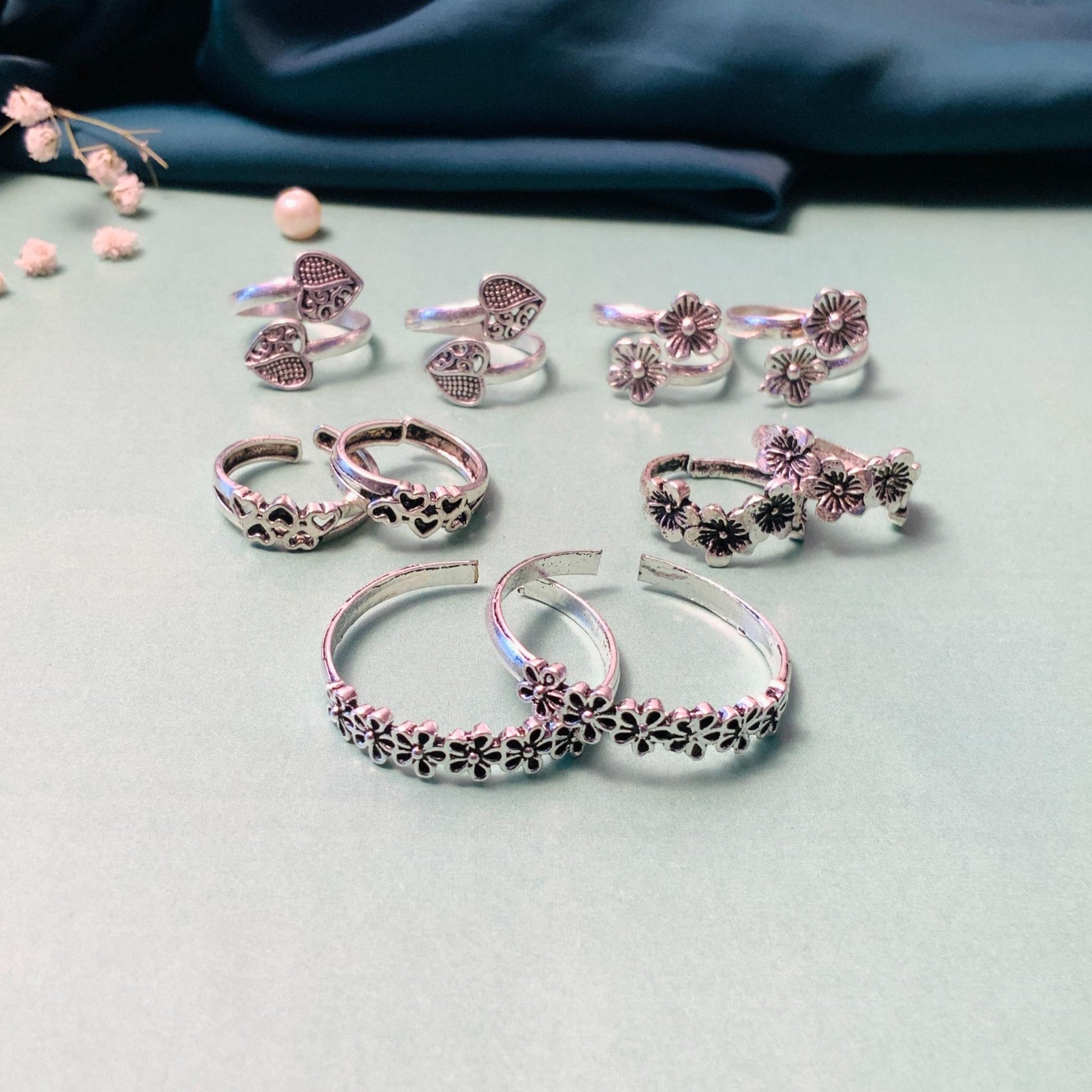 Assorted silver toe rings featuring floral and heart designs for stylish summer accessories