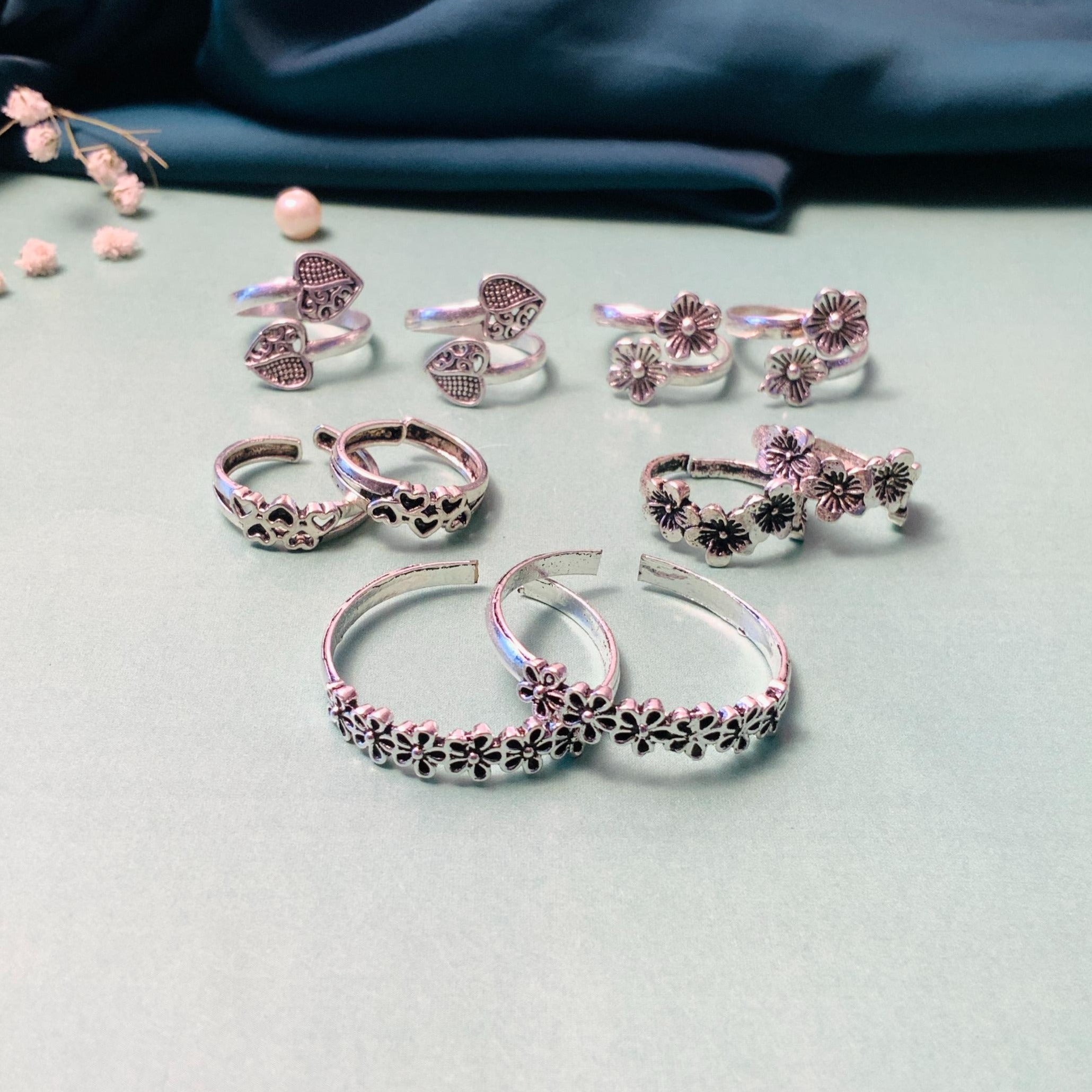 Assorted silver toe rings featuring floral and heart designs for stylish summer accessories