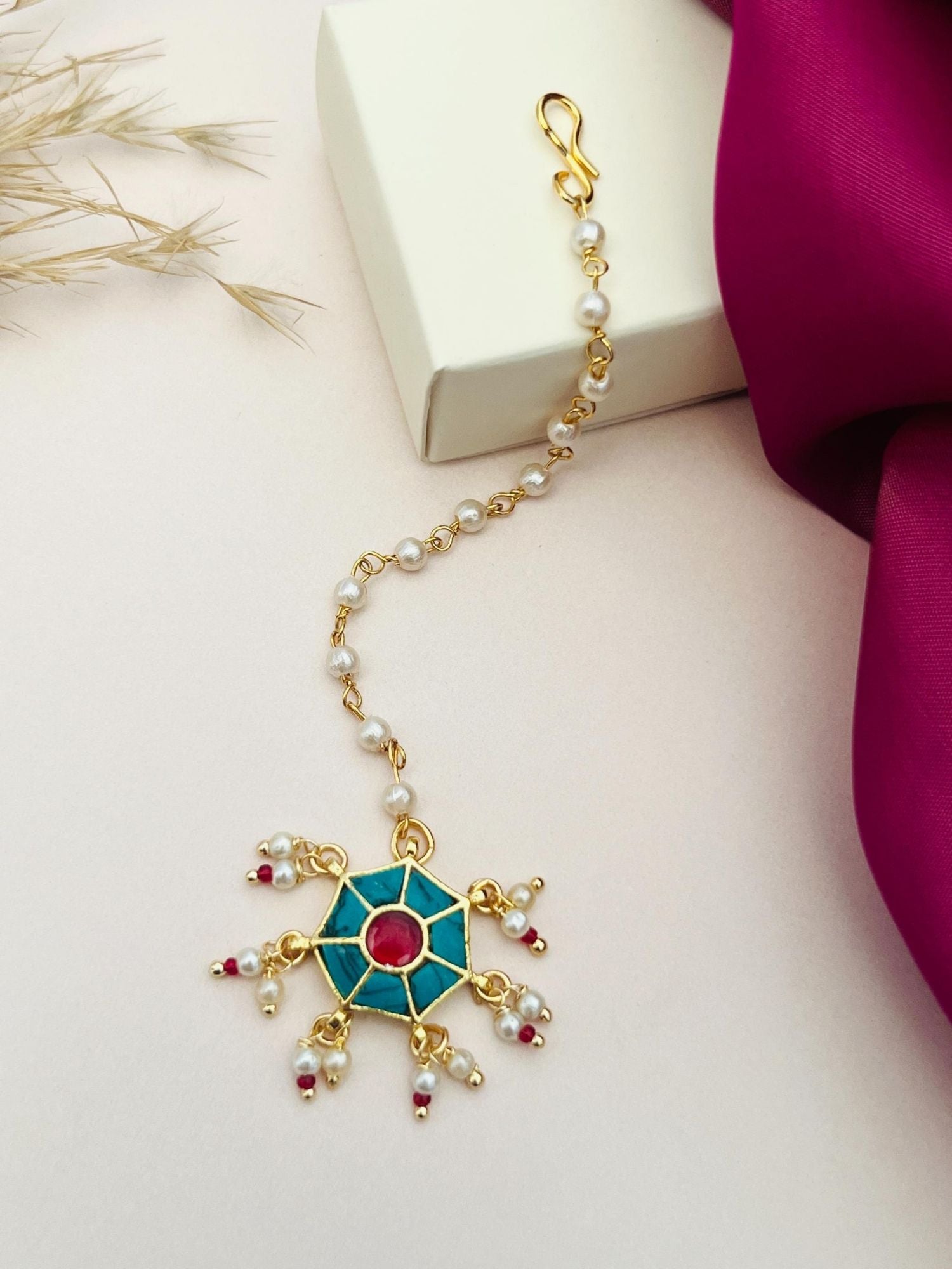 Traditional gold maangtikka with green and red stones and pearl accents by Abdesignsjewellery