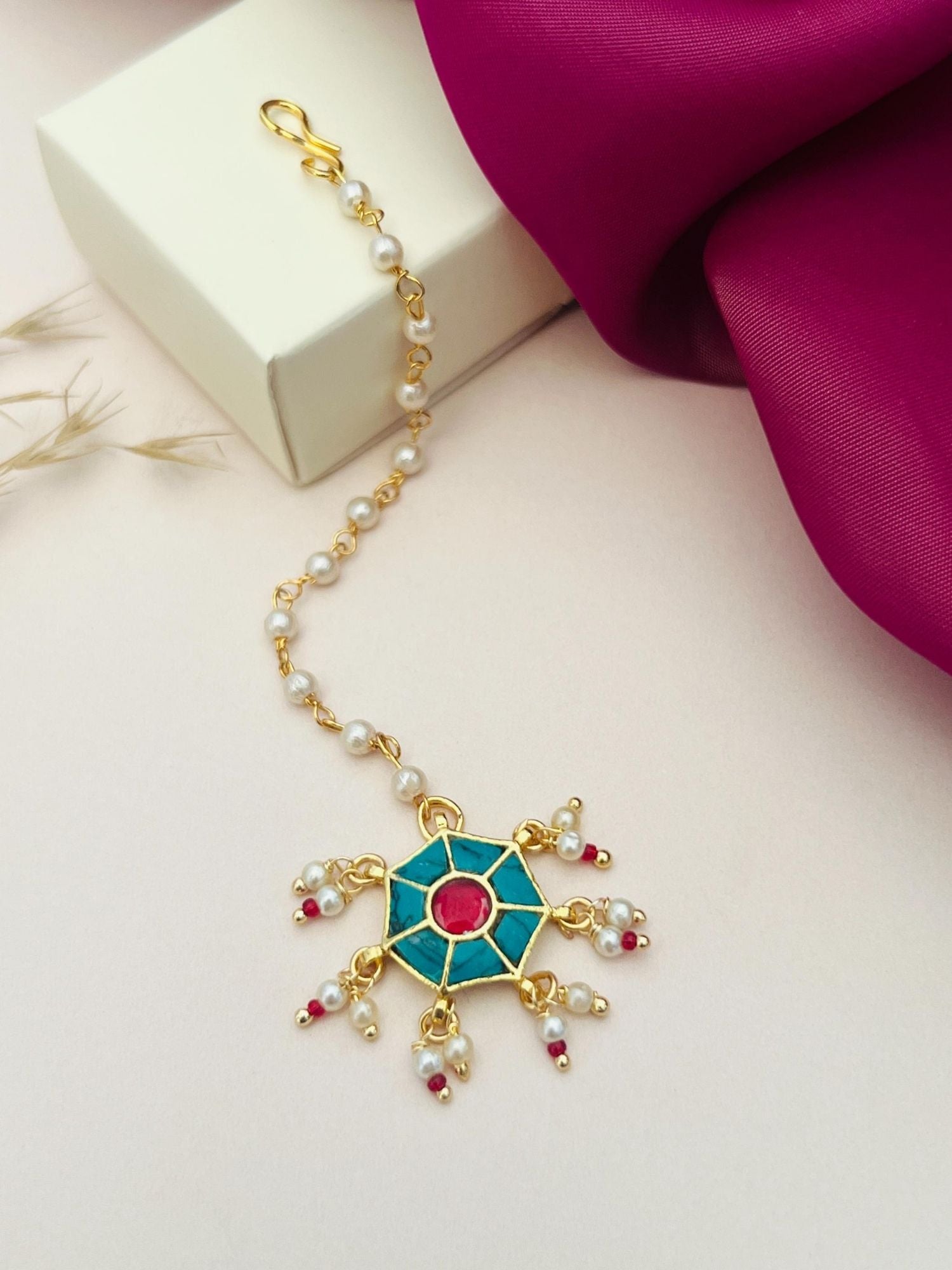 Traditional gold maangtikka with turquoise and red stones and pearl accents from Abdesignsjewellery