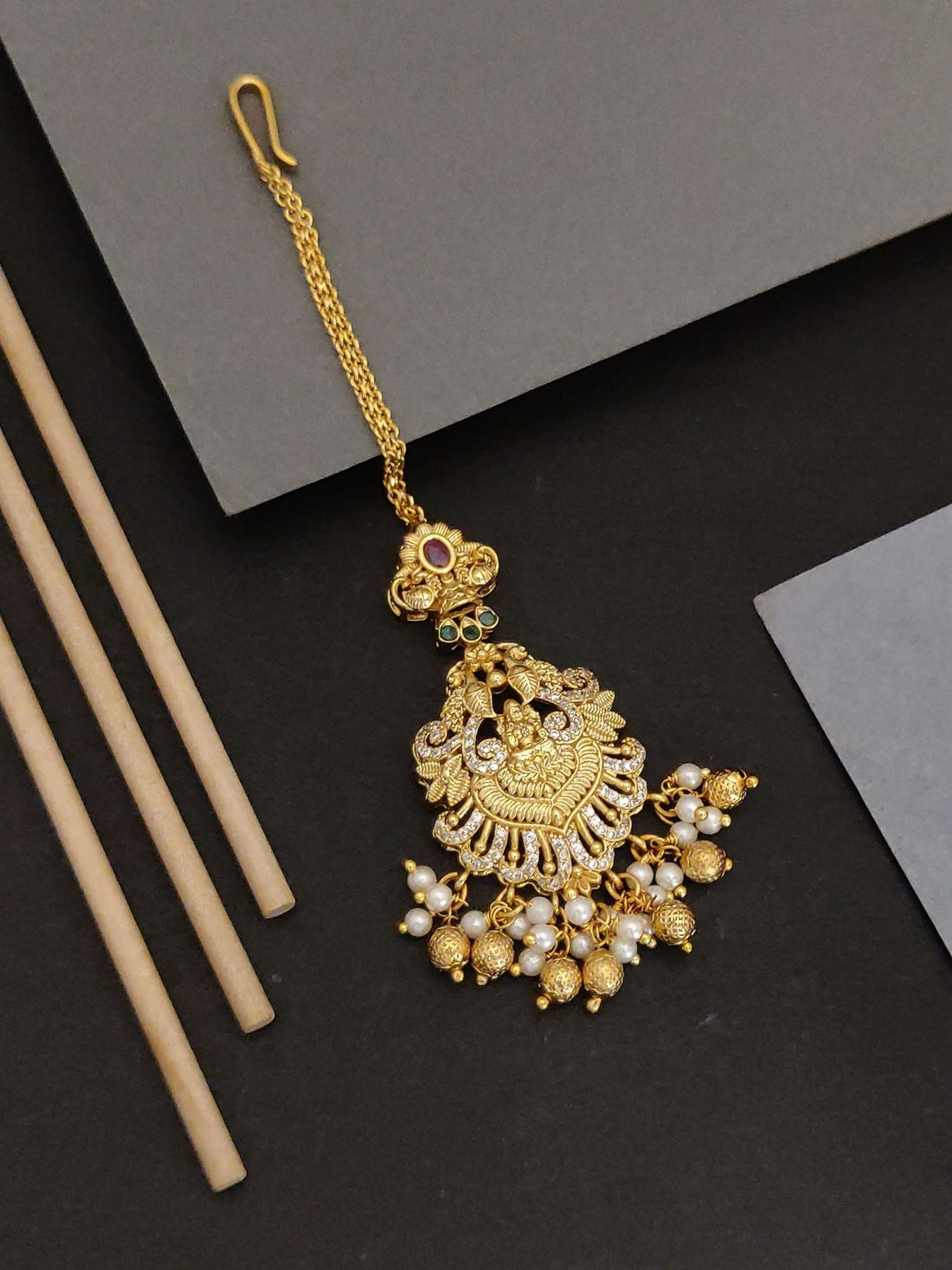Gold plated temple maangtikka with intricate design and pearl embellishments by Abdesignsjewellery