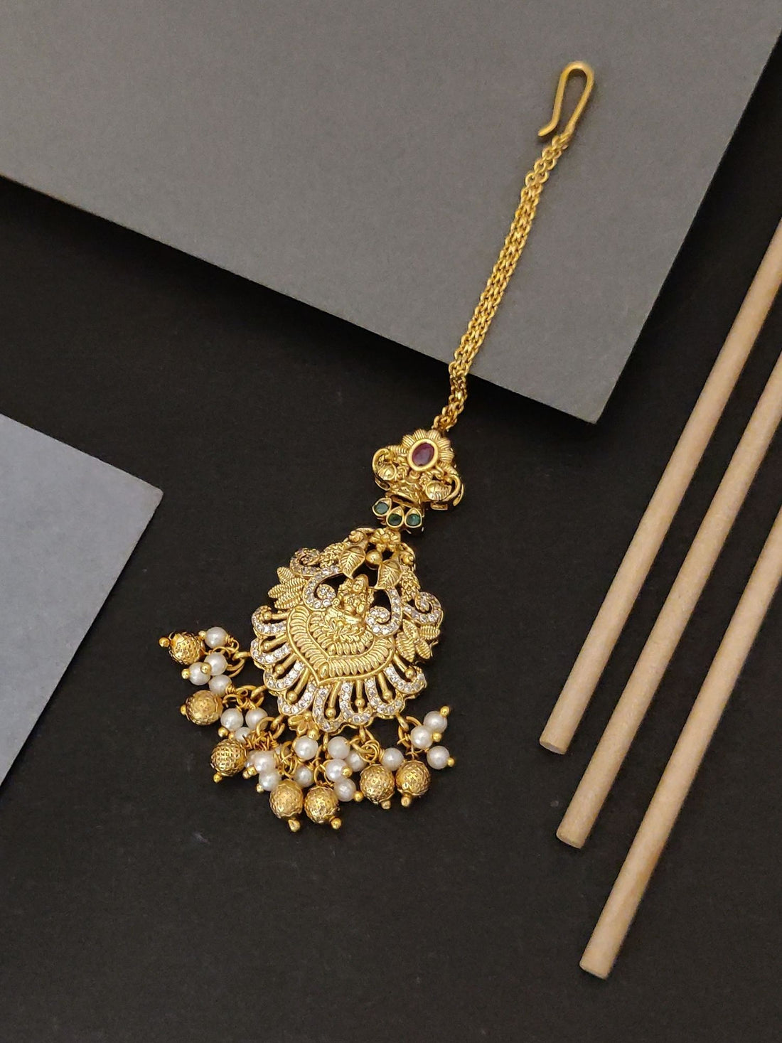 Gold plated temple maangtikka with intricate design and pearl embellishments by Abdesignsjewellery